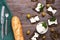 Rye croutons with soft cheese on a wooden surface, top view. a loaf and fork with a knife on a green napkin.