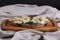 Rye sandwich or bruschetta with ricotta cheese, marinated artichokes and arugula on a wooden board, selective focus.