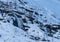 RÃ¸ldal waterfall at the end of winter, mountain slopes covered with snow