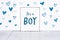 It`s a boy new born baby text on sign board with cute little blue hearts on white background