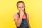It`s lie! Portrait of disgruntled little girl with braid in denim overalls touching her nose and looking angrily