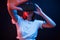 It`s quite interesting. Young woman using virtual reality glasses in the dark room with neon lighting