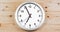 It`s seven o`clock already, time to wake up for breakfast, modern white metallic alarm wall clock on wood