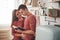 It`s story time. Cute couple reading book together at home in the kitchen at daytime