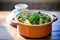 saag aloo in a ceramic pot on a wooden table