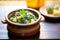 saag aloo in a ceramic pot on a wooden table