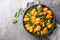 Saag aloo is a classic Indian style side dish featuring potatoes fried in spices and spinach closeup on the bowl. Horizontal top