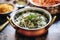 saag aloo in a copper serving bowl, rice behind