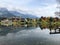 Saalfelden ritzensee with still reflecting water, autumn trees and mountain with clouded tops