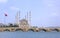 Sabanci Merkez Cami Central Mosque with Tash KÃ¶prÃ¼ Bridge on the Seyhan River with Turkish flags next to it in cloudy weather in