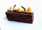 Sacher Torte cake with apricot pieces and orange microwave sponge decoration on white
