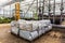 Sacks with soil and fertilizers against background of pipe system in modern industrial greenhouse, hothouse equipment