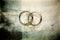 Sacrament: Matrimony. Two golden wedding rings on grunge background