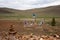 Sacred pillars with ribbons for shamanistic rites on a background of hills.