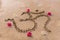 The sacred syllable om with frangipani flowers on the sand