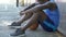 Sad African-American basketball player sitting on the ground, lack of motivation