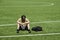 Sad alone teenage boy with backpack sitting in empty sport stadium outdoors