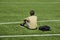 Sad alone teenage boy with backpack sitting in empty sport stadium outdoors