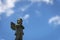 A sad angel against the blue sky in a cemetery in the city of New Orleans