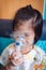 Sad asian child holds a mask vapor inhaler for treatment of asthma.