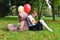 Sad baby girl with big teddy bear and balloons in the park.  Problems teenagers at school