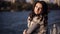 Sad beautiful girl walking on the bridge. Autumn city in the background. soft light