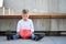 A sad boy holding a red moneybox and suitcase.