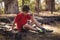 Sad boy relaxing on tyre during obstacle course