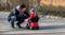 Sad boy is sitting on a red push car and listening to his father explaining to him road law and traffic rules. Kid safety concept