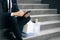 Sad businessman sitting on stairs outdoor with box of personal stuff. Despaired male lost work place and looking for a