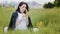 Sad caucasian woman upset pretty girl sits on grassland spends time outdoors alone chatting cellphone scrolls program