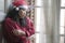 Sad Christmas home alone during covid19 - young beautiful and depressed Asian Chinese woman in Santa Claus hat looking melancholic