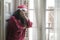 Sad Christmas home alone during covid19 - young beautiful and depressed Asian Korean woman in Santa Claus hat looking melancholic