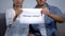 Sad couple holding marriage contract phrase on cardboard, divorce problem