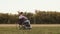 Sad disabled man is sitting in field in wheelchair and is sad, reflecting on his diagnosis, back view. Concept of