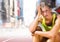 Sad disappointed athlete runner sitting down in city
