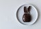 Sad Easter because of the coronavirus - concept photo with a broken Easter bunny on a plate on the white table with copy space