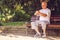 Sad elderly man with his walking stick sitting on bench
