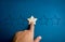 Sad emotion face on a wooden star pointing by hand on blue background. Negative reviews in customer and relations service.