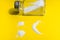 Sad face made of salt on a yellow background - the concept of the harm of salt to health