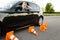 Sad female student in car, all cones are downed