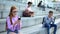 Sad female student in eyeglasses typing smartphone message sitting campus stairs