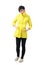 Sad freezing woman in yellow raincoat with hands in pockets