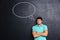 Sad frowning young man standing over chalkboard background