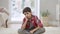 Sad frustrated Middle Eastern boy sitting on carpet at home thinking. Portrait of lonely depressed bullied child alone