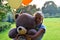 Sad girl child hugs a big teddy bear and balloons in the park. Schoolgirl unhappy in the park with a big toy and balls