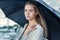 Sad girl hiding under a black umbrella from the rain, standing on the banks of the river. Curls of hair develop in the wind. Storm