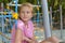 Sad girl sits alone on the playground in summer. lonely teenager girl misses