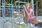 Sad girl sits alone on the playground in summer. lonely teenager girl misses