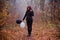 Sad girl walking in dark clothing in autumn forest, with balloons, black and white. Concept of choice, good and evil